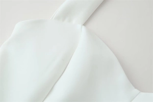 Close-up of high-quality woven fabric texture and stitching details on white halter top