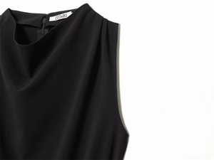 Detail of black sleeveless top featuring a draped neckline and pleated shoulder design