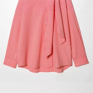 Red and white vertical striped blouse with neck tie bow and long sleeves in flat lay
