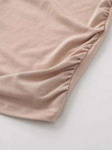 Detail of soft pink knitted fabric featuring side ruched pleated texture and stitching