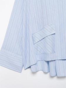 Detail of light blue striped shirt featuring oversized flap pocket and wide cuffs