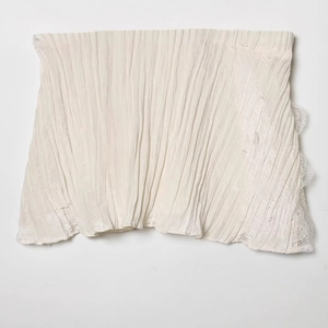 Beige pleated camisole top with delicate white lace trim in flat lay view