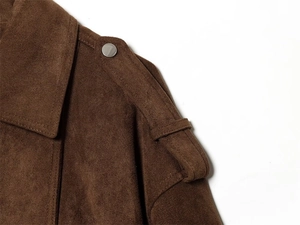Detailed macro shot of dark brown suede jacket featuring epaulettes and metallic buttons