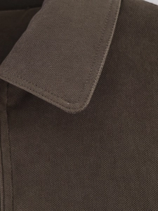 Macro detail of high-quality stitching on the polo collar of a brown twill cotton jacket
