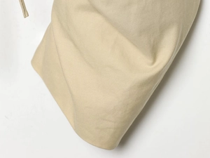Macro view of beige twill fabric texture and drawstring detail on a women trench coat
