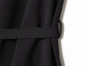Detail of a black sleeveless top showing the matching fabric belt and stitched loops