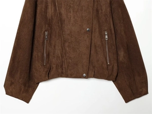 Close-up of dark brown suede jacket featuring silver zipper pockets and hem details