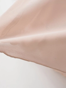 Macro shot of breathable light pink mesh fabric with fine overlock stitching details