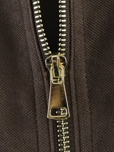 Detail view of premium gold metal zipper and smooth teeth on brown polo jacket fabric