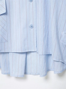 Detail of light blue striped shirt featuring cotton texture and small buttons