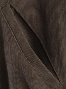 Detail of diagonal pocket with reinforced stitching on dark brown polo collar jacket