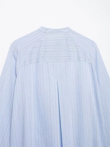 Detail view of light blue striped shirt back showing pleated yoke and stand-up collar design
