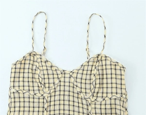 Detail of yellow plaid camisole top featuring lace trim and sweetheart neckline texture