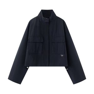 Detail of black utility jacket with stand collar, flap pockets, and adjustable drawstring hem