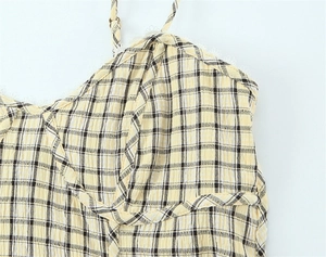 Detail view of yellow plaid top featuring delicate lace trim and adjustable straps