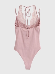 Détail du body rose clair montrant les patchworks de dentelle et le tissu soyeux