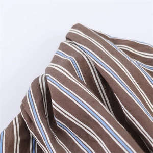 Detailed macro shot showing brown and blue vertical stripes on a cotton fabric texture