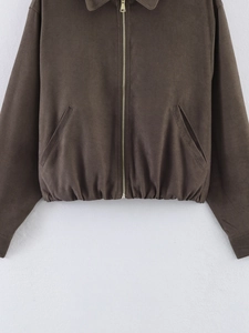 Close-up of brown canvas jacket with golden zipper and elasticated hem details