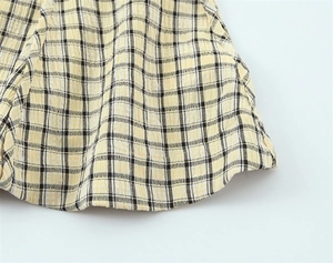 Close-up of yellow and black plaid seersucker fabric with breathable puckered texture