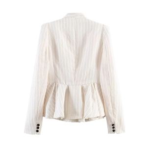 Detail view of the striped peplum hem and three-button cuffs on a white blazer