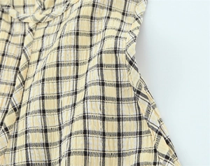 Macro shot of yellow and black plaid seersucker fabric texture with puckered surface