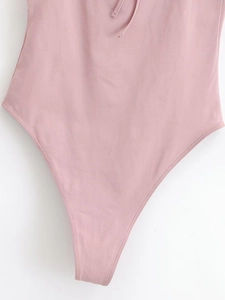 Détail du body rose montrant la coupe échancrée, le lien à nouer et les coutures de qualité