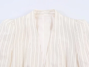Detail of white striped blazer showing puff sleeves and shawl collar texture