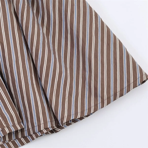 Detailed view of striped cotton fabric showing vertical brown blue stripes and fine stitching