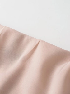 Close-up of soft nude pink fabric texture with elegant drapes and smooth weaving pattern