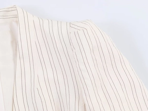 Detailed view of striped blazer shoulder with refined stitching and padded structure