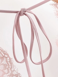 Détails de coutures en dentelle rose et liens tricotés délicats sur le body