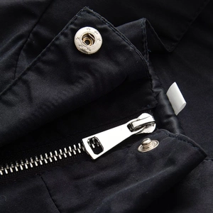 Close-up of metal zipper and snap button with star pattern on cotton jacket