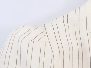 Detailed close-up showing the striped fabric texture and stitching of the blazer shoulder