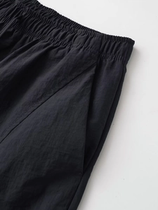 Detailed macro view of black elastic drawstring waistband and side pockets on track pants