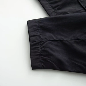 Detailed macro view of neat stitching on dark blue woven fabric hem of casual jacket