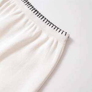 White knit skirt waist featuring black blanket stitch detail and ribbed elastic texture