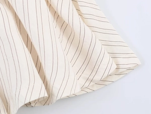 Macro shot of beige striped fabric texture and vertical pattern for women's blazer