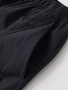 Detail shot of black stretch waist utility pants with elastic drawstring and side pockets