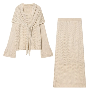 Detail of beige pointelle knit set featuring intricate hollow-out texture and tie-up shawl