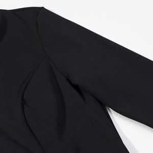 Close-up of black lace patchwork top showing fabric texture and shoulder seam details