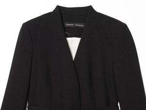 Détail du col d'un blazer noir avec doublure rayée et étiquette de marque intérieure