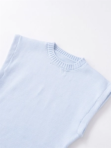 Detailed knit texture and ribbed round neckline of a light blue sleeveless sweater vest
