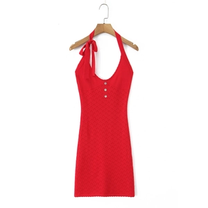 Detail of red knitted mini dress with v-neckline, accent buttons and large shoulder bow tie