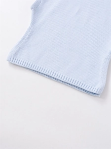 Close-up of light blue knitted sweater showing fine texture and ribbed hem detail