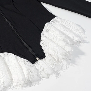 Close-up of black knit top featuring white eyelash lace hem and metal zipper detail