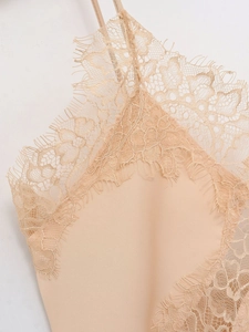 Close-up of elegant eyelash lace trim and silky satin fabric on a champagne camisole