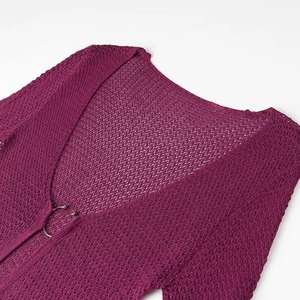 Detail of purple hollow crochet knit dress with V-neck and metal ring buckle closure