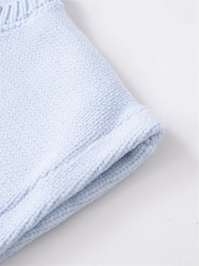 Detailed macro view of the sky blue knitted fabric texture on the edge of the sweater