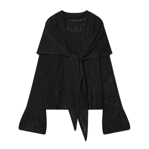 Detail view of black knit cardigan featuring hollow crochet lace and front tie design