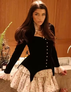Close-up of velvet long-sleeved top with pearl buttons and floral ruffle trim detail